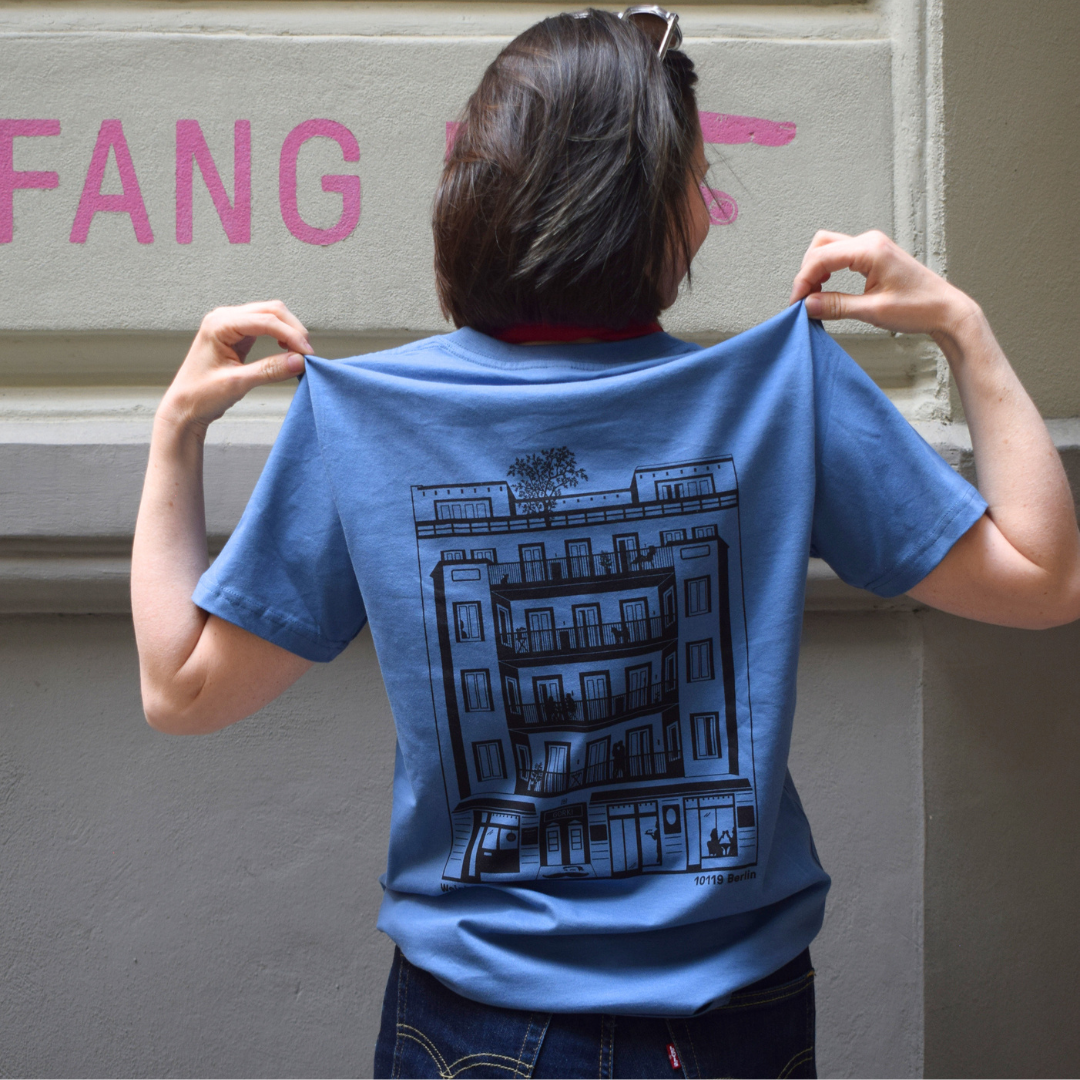 Blaues T-Shirt mit dem GORKI Logo auf der Vorderseite und unsere Fassade auf der Rückseite