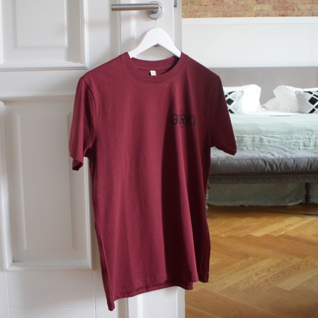 Rotes T-Shirt mit dem GORKI Logo auf der Vorderseite und unsere Fassade auf der Rückseite