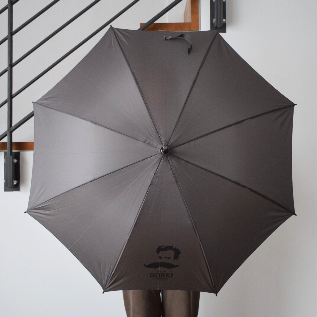 Grauer Regenschirm mit GORKI Apartments Logo